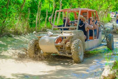 A dune buggy throwing up red dust on the track to Macao Beach